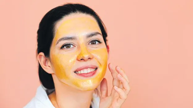 Woman with a golden honey face mask, showing honey in a skincare routine